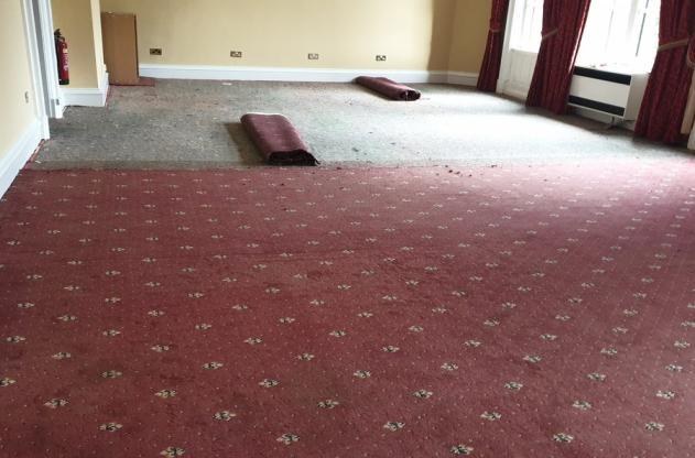Before - existing carpet and public-use room condition.